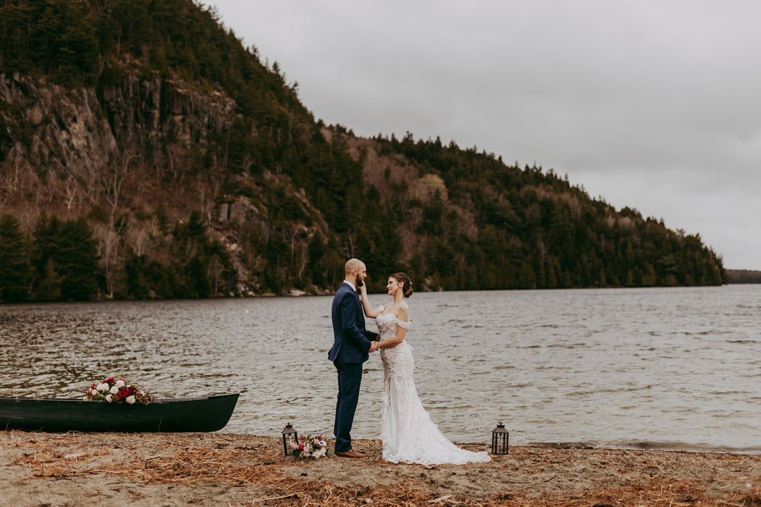 A bride and groom getting married next to a lake with boat