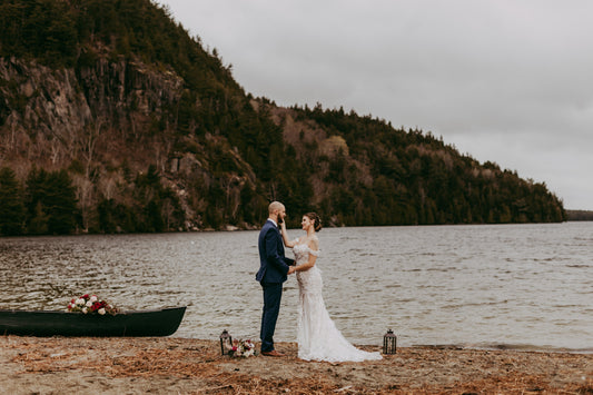 A bride and groom getting married next to a lake with boat