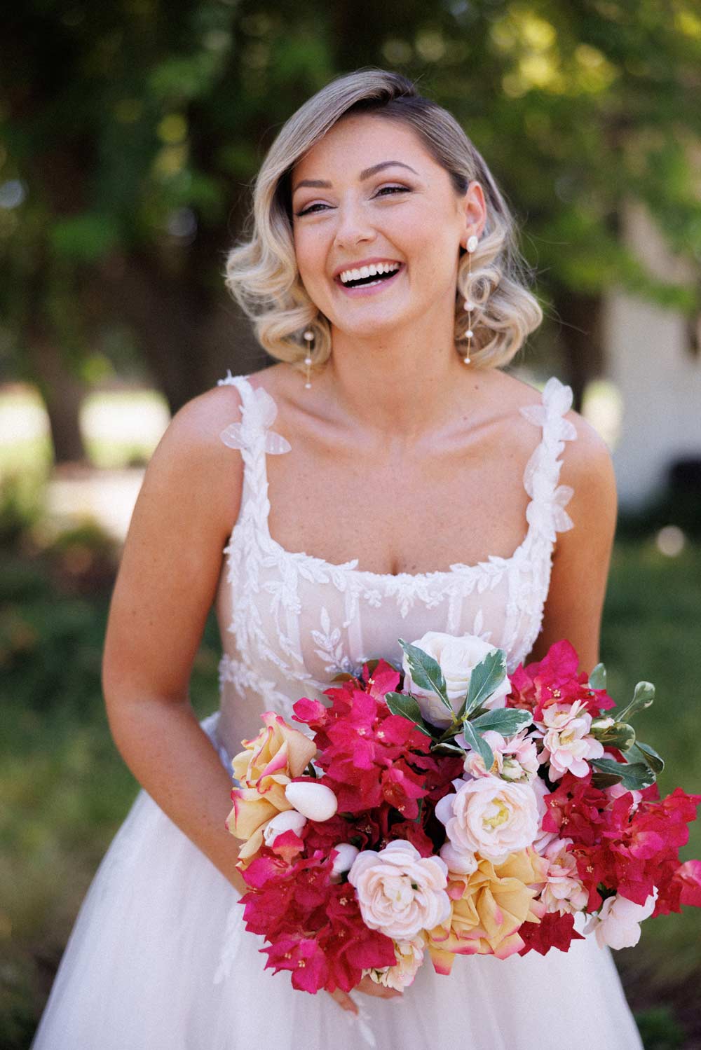 A bride holding a bouquet smile happily